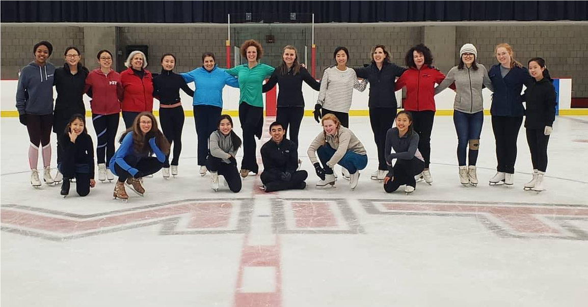 Many skaters posing at center ice