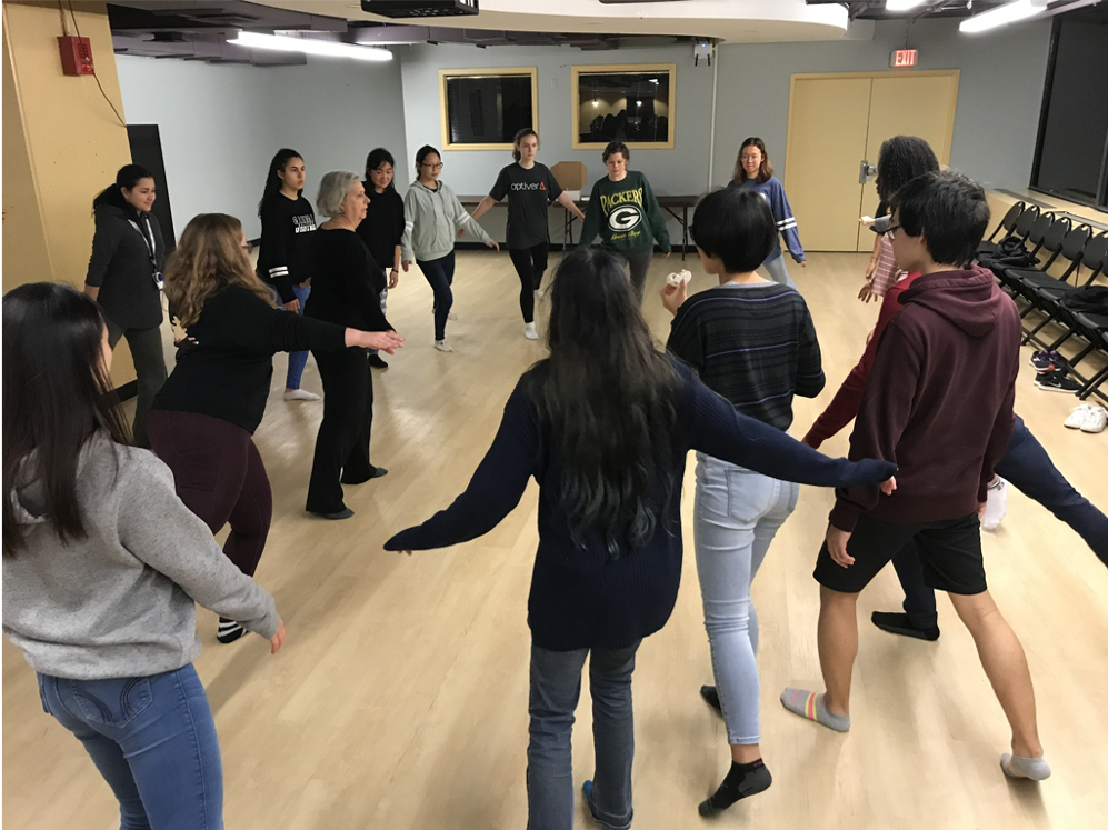 Students practicing skating on the floor wearing socks